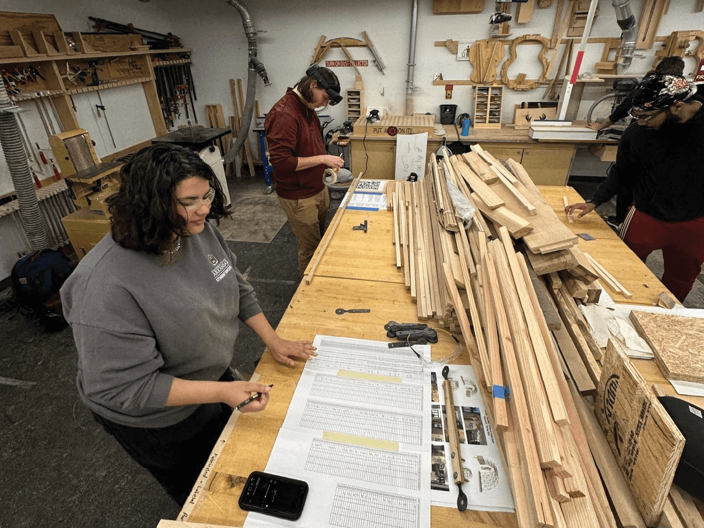 Students in the woodshop mark wooden struts using holographic guides